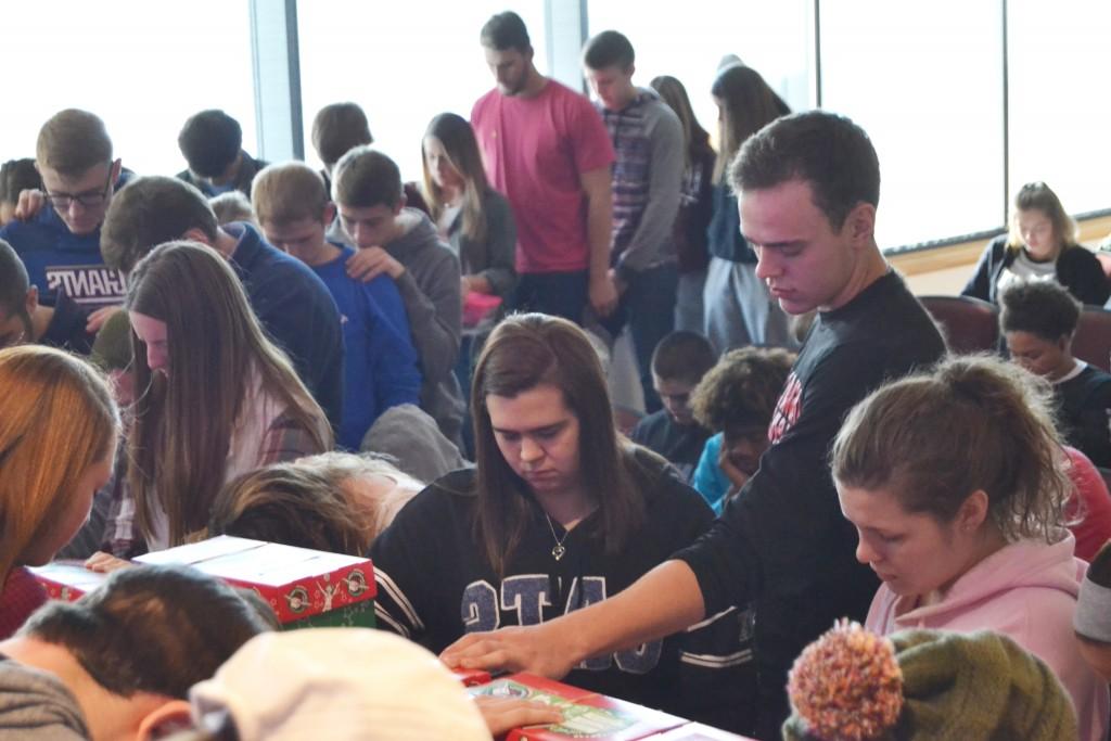 Several Campbellsville University students praying for the Operation Christmas Child boxes before sending them out to the world. (Campbellsville University Photo by Jordan Snider)